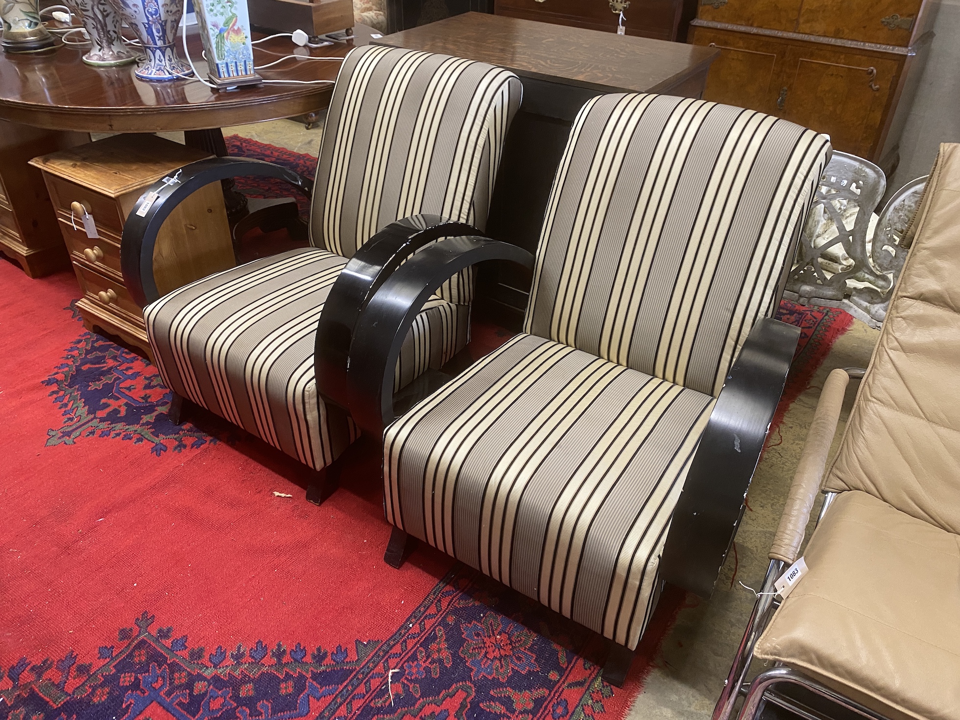 A pair of Deco style ebonised upholstered armchairs, width 78cm, depth 92cm, height 87cm